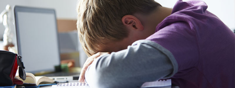 boy leaning over desk