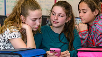 girls smiling while doing school work